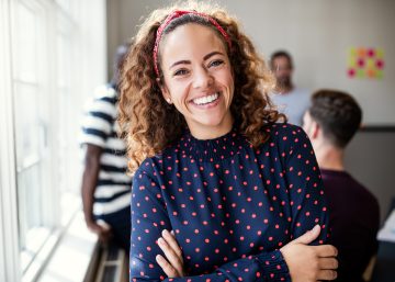 Smiling Female Designer Standing In An Modern Office