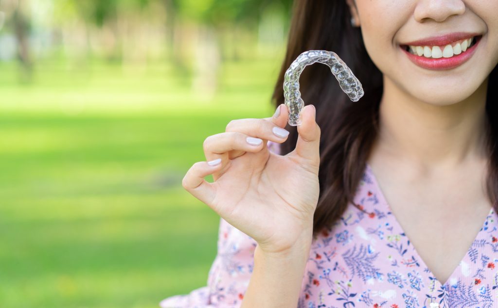 Close Up Young Beautiful Asian Woman Smiling With Hand Holding Clear Aligners