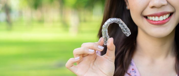 Close Up Young Beautiful Asian Woman Smiling With Hand Holding Clear Aligners