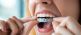 Woman putting in clear aligners West Michigan dentists MI Smiles